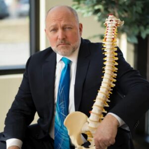 Doctor holding model of a spine